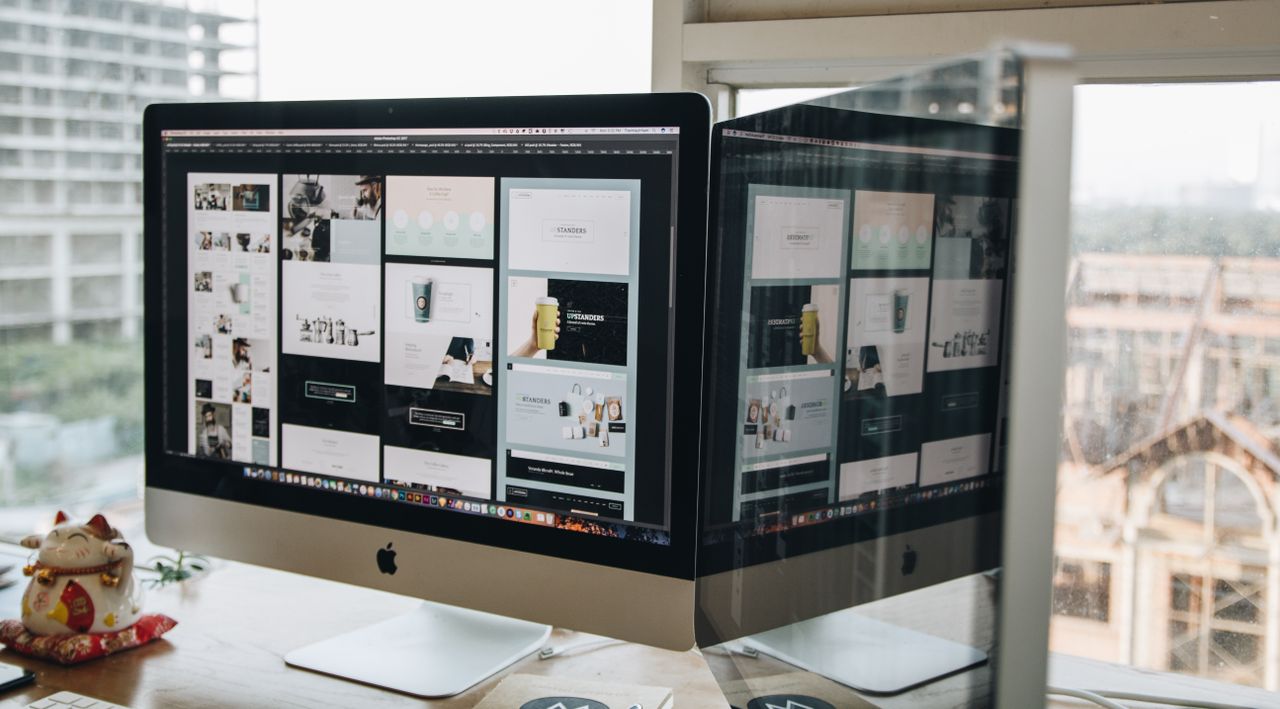 Deux écrans sur un bureau, illustrant la conception web dans un environnement de bureau moderne.